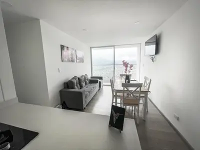 a living room with a couch and a table at Maravillosas vistas, excelente ubicación in Manizales