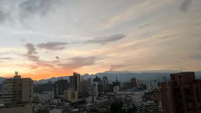 a city skyline at sunset with buildings and mountains at Apartamento Vista Panoramica 3 habitaciones 2 baños - Av Santander Sector El Cable y Estadio Palogrande in Manizales