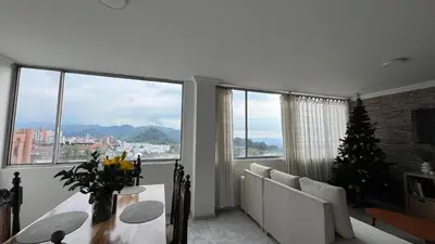 a living room with a table and a christmas tree at Apartamento Vista Panoramica 3 habitaciones 2 baños - Av Santander Sector El Cable y Estadio Palogrande in Manizales