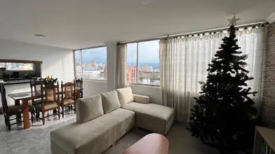 a living room with a christmas tree in front of a window at Apartamento Vista Panoramica 3 habitaciones 2 baños - Av Santander Sector El Cable y Estadio Palogrande in Manizales
