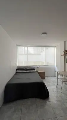 a bedroom with a large bed and a table at Apartamento Vista Panoramica 3 habitaciones 2 baños - Av Santander Sector El Cable y Estadio Palogrande in Manizales