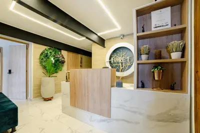 a lobby with potted plants and a sign on the wall at Foret Lofts in Medellín