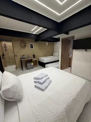 a bedroom with a white bed with towels on it at Foret Lofts in Medellín