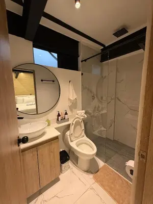a bathroom with a toilet and a sink and a shower at Foret Lofts in Medellín