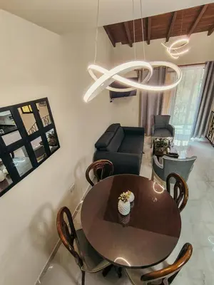 a dining room with a table and chairs and a chandelier at Paco House in Jardin