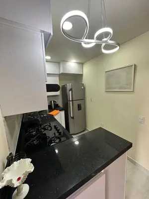 a kitchen with a black counter top and a refrigerator at Paco House in Jardin