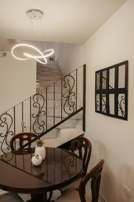 a dining room with a table and a staircase at Paco House in Jardin