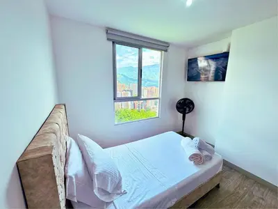 a small bedroom with a bed and a window at 3BR Stunning 19th Floor Views Pool Sabaneta in Sabaneta