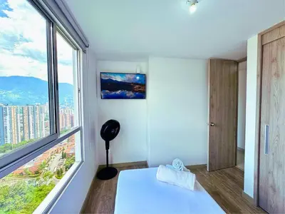 a room with a bed and a large window at 3BR Stunning 19th Floor Views Pool Sabaneta in Sabaneta