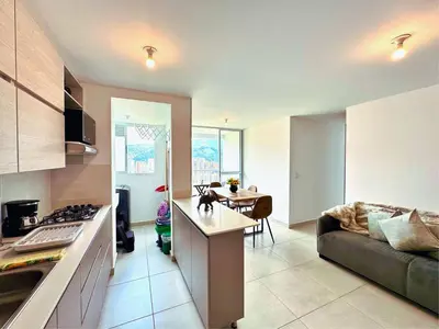 a kitchen and living room with a couch and a table at 3BR Stunning 19th Floor Views Pool Sabaneta in Sabaneta