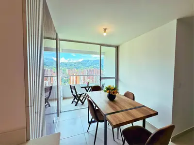 a dining room with a table and chairs and a balcony at 3BR Stunning 19th Floor Views Pool Sabaneta in Sabaneta