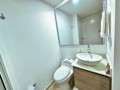 a bathroom with a sink and a toilet and a mirror at 3BR Stunning 19th Floor Views Pool Sabaneta in Sabaneta