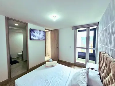 a bedroom with a bed and a large window at 3BR Stunning 19th Floor Views Pool Sabaneta in Sabaneta