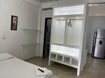 a white room with a bed and a refrigerator at Apartamento Nápoles in Doradal