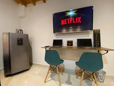 a meeting room with two laptops on a desk with a television at Fraternity Room, Habitación Deluxe - solo a una cuadra del parque in Carmen de Viboral