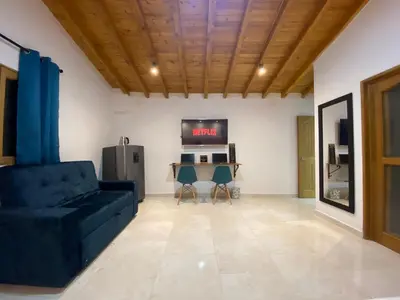 a living room with a couch and a tv at Fraternity Room, Habitación Deluxe - solo a una cuadra del parque in Carmen de Viboral