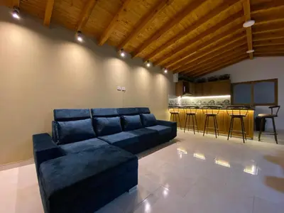 a living room with a blue couch and a kitchen at Fraternity Room, Habitación Deluxe - solo a una cuadra del parque in Carmen de Viboral
