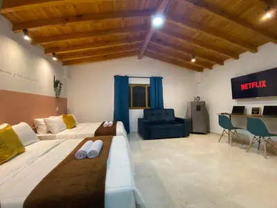 a living room with two beds and a desk at Casa Dorada - Confort a solo una cuadra del Parque in Carmen de Viboral