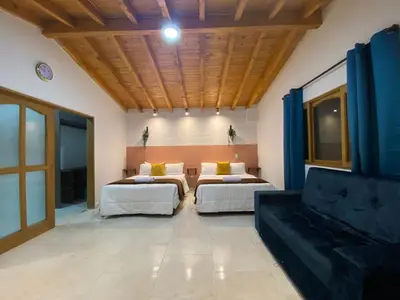 a bedroom with two beds and a couch at Casa Dorada - Confort a solo una cuadra del Parque in Carmen de Viboral