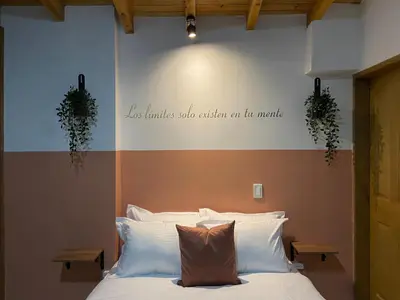 a bedroom with a bed with a quote on the wall at Casa Dorada - Confort a solo una cuadra del Parque in Carmen de Viboral