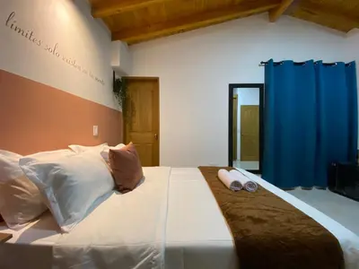 a bedroom with a large white bed with two pillows at Casa Dorada - Confort a solo una cuadra del Parque in Carmen de Viboral
