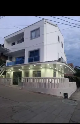 a white building with a fence in front of it at Apt vacacional 301 in Doradal