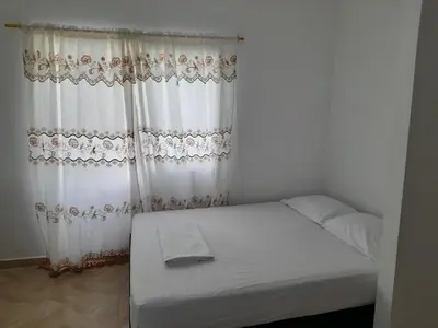 a small bedroom with a bed with white curtains at Apt vacacional 301 in Doradal
