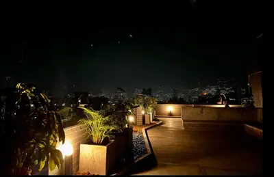 a night view of a rooftop with plants and lights at Encantador Loft urbano en el corazón de Medellín in Medellín