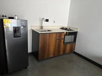a small kitchen with a sink and a refrigerator at Encantador Loft urbano en el corazón de Medellín in Medellín