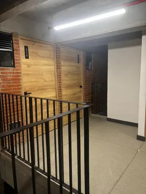 a hallway with two wooden doors in a building at Encantador Loft urbano en el corazón de Medellín in Medellín