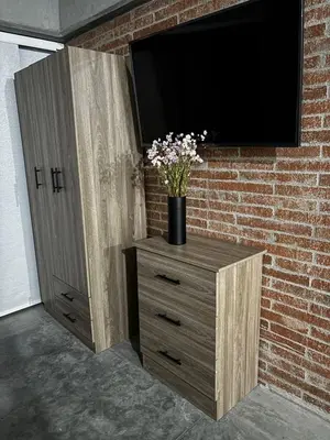 a wooden dresser with a television on a brick wall at Encantador Loft urbano en el corazón de Medellín in Medellín