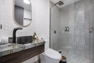 a bathroom with a toilet and a sink and a shower at Luxury Retreat Private Sauna, Jacuzzi, Pool table, Games, Very Large 5 Bedrooms Complete Apartment in Medellín