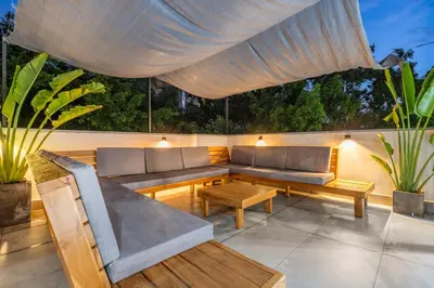 a patio with a couch and tables and a canopy at Luxury Retreat Private Sauna, Jacuzzi, Pool table, Games, Very Large 5 Bedrooms Complete Apartment in Medellín