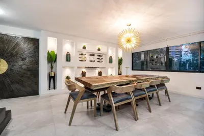 a dining room with a wooden table and chairs at Luxury Retreat Private Sauna, Jacuzzi, Pool table, Games, Very Large 5 Bedrooms Complete Apartment in Medellín