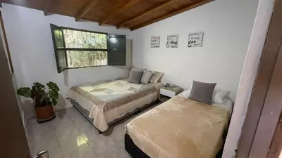 a bedroom with two beds and a window at Finca en el corazón de llanogrande in Rionegro