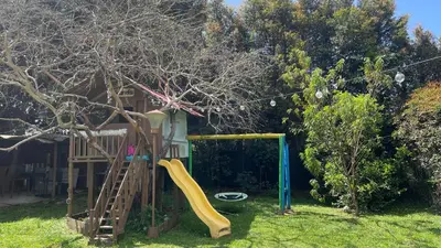 a playground with a slide in a yard at Finca en el corazón de llanogrande in Rionegro