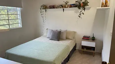 a bedroom with a bed and a small night stand at Finca en el corazón de llanogrande in Rionegro