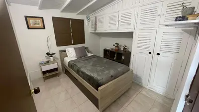 a small bedroom with a bed and white cabinets at Finca en el corazón de llanogrande in Rionegro