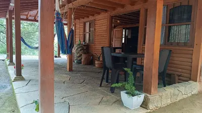 a porch of a house with a table and chairs at Finca la carolina in Medellín