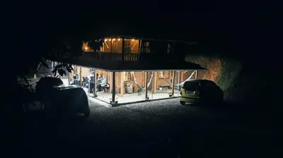 a house with a balcony and a car in the dark at Finca la carolina in Medellín