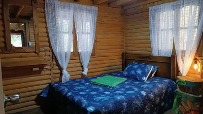 a bedroom with a bed in a log cabin at Finca la carolina in Medellín