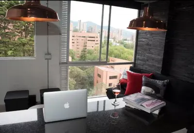 a living room with a laptop computer on a table at EXCLUSIVO APARTAMENTO para disfrutar Medellin in Medellín