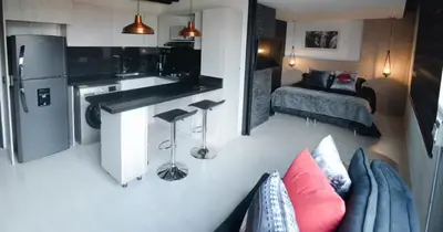 a kitchen and a living room with a couch and a kitchen at EXCLUSIVO APARTAMENTO para disfrutar Medellin in Medellín