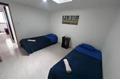a room with two beds and a sign on the wall at Casa Amplia y Cómoda - Estrato 5 in Manizales