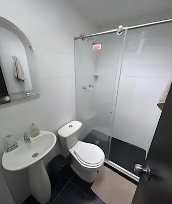 a bathroom with a toilet and a sink and a shower at Casa Amplia y Cómoda - Estrato 5 in Manizales