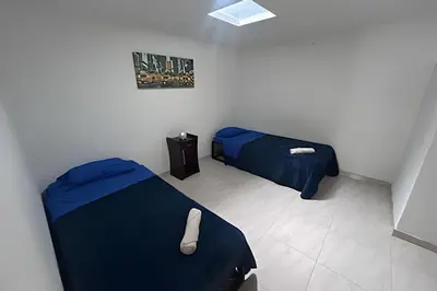 two beds in a room with blue sheets at Casa Amplia y Cómoda - Estrato 5 in Manizales