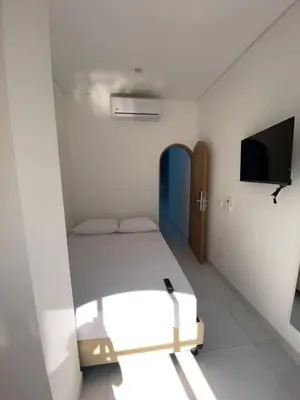 a small room with a bed and a flat screen tv at Habitaciones en Doradal 205 in Doradal