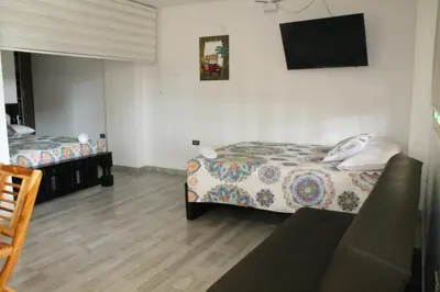 a bedroom with two beds and a couch in it at Apartahotel Avverato in Guatapé