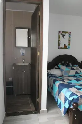 a bedroom with a bed with a sink and a mirror at Apartahotel Avverato in Guatapé