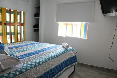 a bedroom with a bed and a window at Apartahotel Avverato in Guatapé